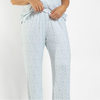 A person wearing a light blue and white patterned short-sleeve pajama shirt and matching pants, shown from the shoulders to the upper thighs against a plain light background.