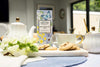 Tea set with cookies and a box of Farmhouse Biscuits on a table.