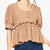 Woman wearing a beige top and blue jeans on a white background