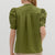 Person wearing a green blouse with puff sleeves on a white background